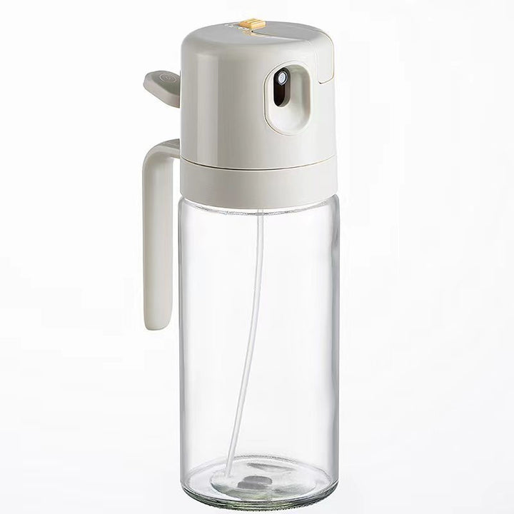 "Automatisk sprayflaske SprayEase i klart glas med sort låg, ideel til præcis oliefordeling i køkkenet."