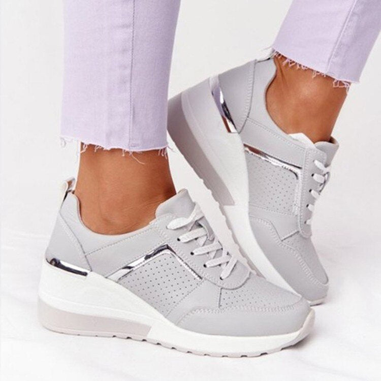 Nærbillede af stilfulde beige og hvide platform sneakers til kvinder. Fremhæver trendy design og snøredetaljer.