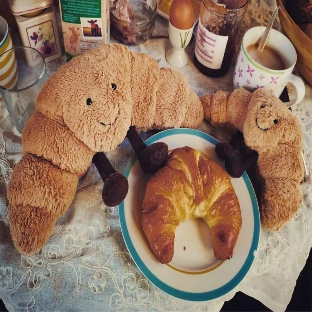 Unik gaveidé: Humoristisk croissant krammebamse, blød og behagelig for alle aldre.