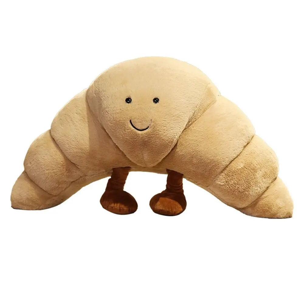 En blød og humoristisk croissant krammebamse, skøn som pyntepude og legetøj.