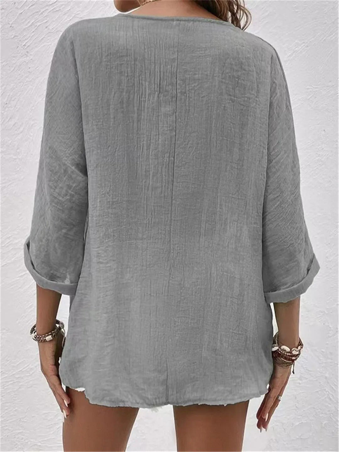 Model bærer casual V-hals damebluse med trekvart ærmer i bomuld. Perfekt til et afslappet sommerlook.