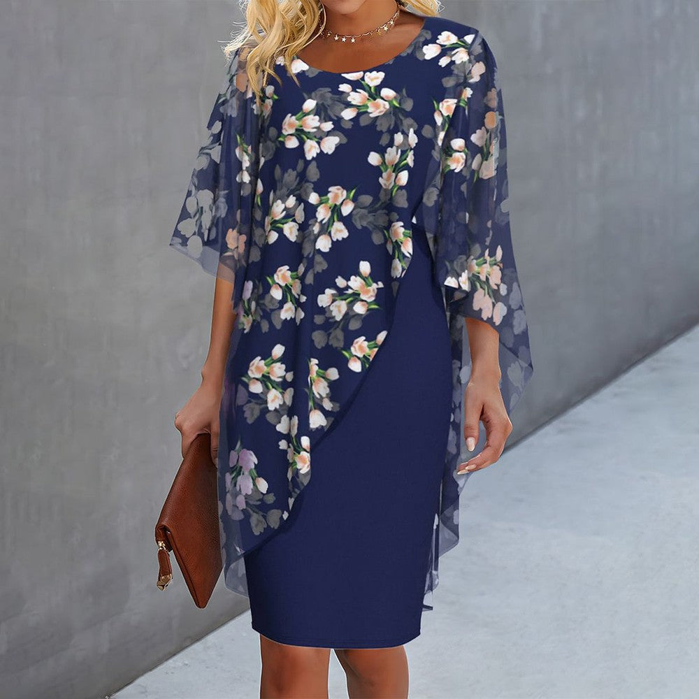 "Cleo floral kjole med blomstermønster og gennemsigtigt lag, asymmetrisk kant for moderne look, feminin elegance."