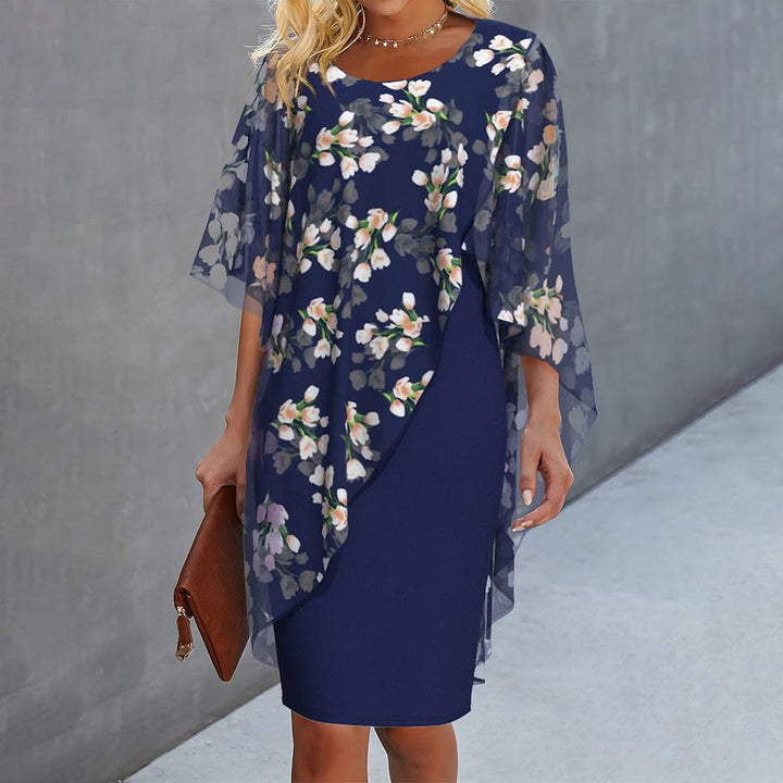 "Cleo floral kjole med blomstermønster og gennemsigtigt lag, asymmetrisk kant for moderne look, feminin elegance."