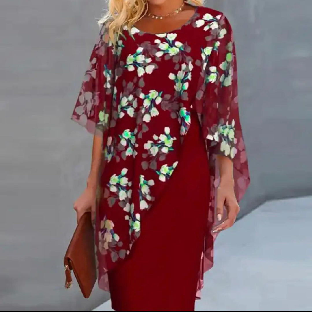 "Cleo floral kjole med blomstermønster og gennemsigtigt lag, asymmetrisk kant for moderne look, feminin elegance."