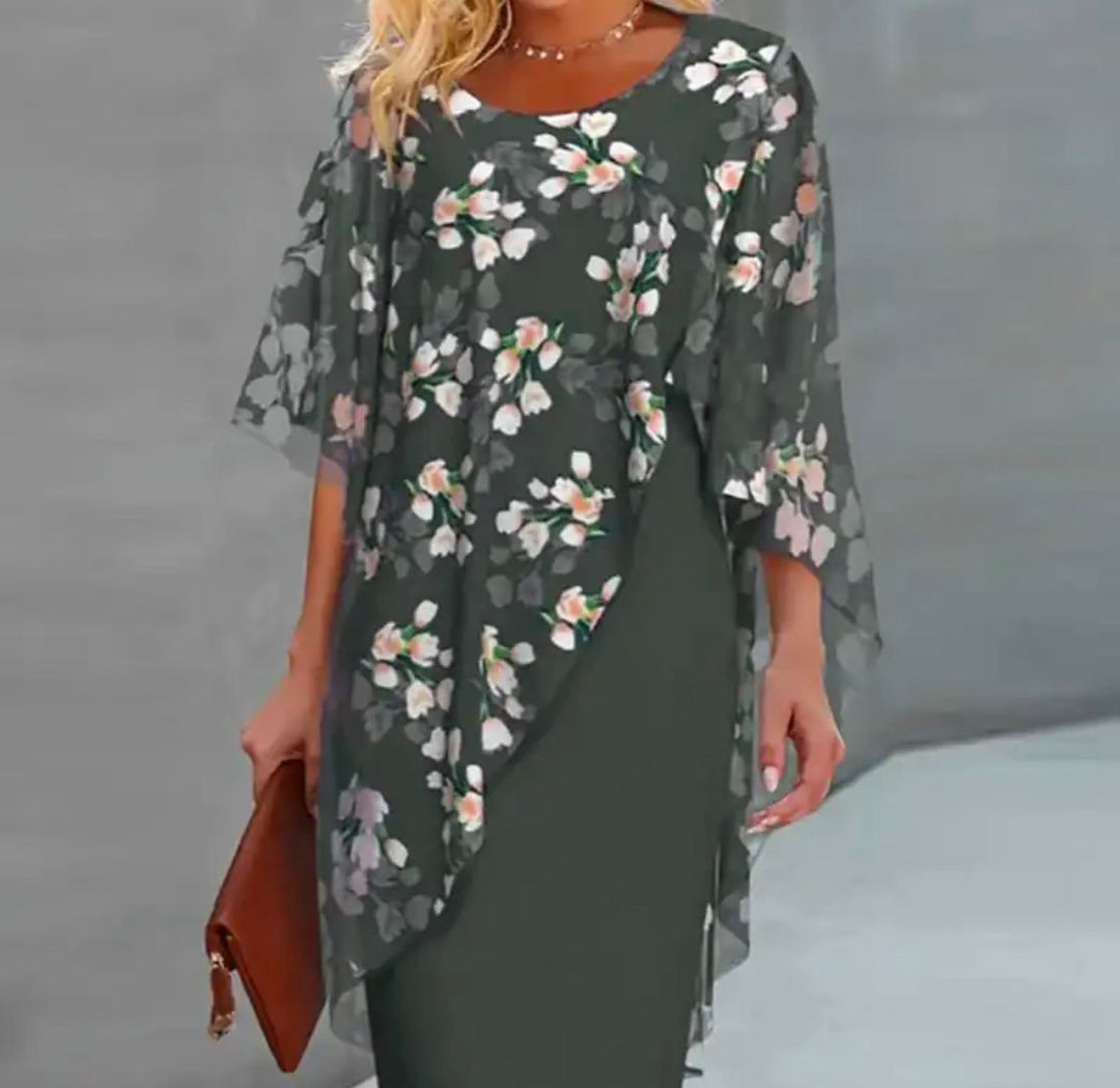 "Cleo floral kjole med blomstermønster og gennemsigtigt lag, asymmetrisk kant for moderne look, feminin elegance."