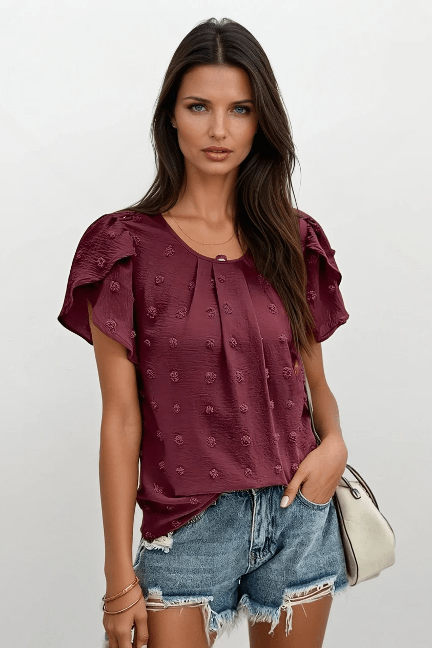 Dame Carlota bluse med struktur og feminine flæseærmer, perfekt til sommer og hverdag.