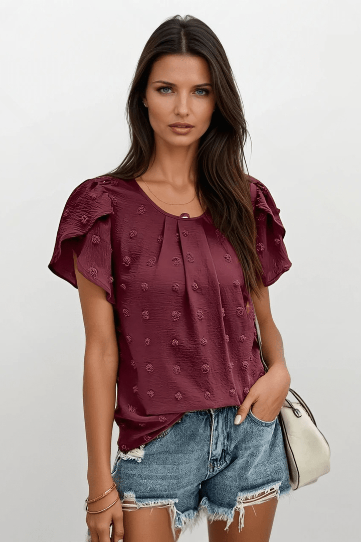 Dame Carlota bluse med struktur og feminine flæseærmer, perfekt til sommer og hverdag.