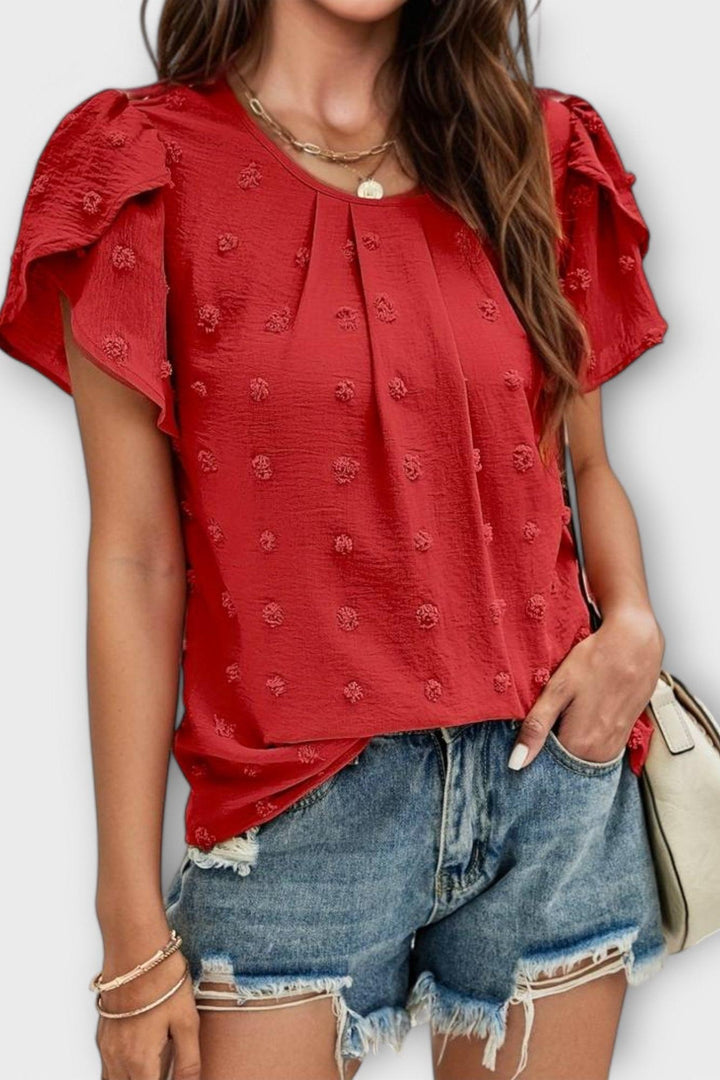 Carlota damebluse med struktur og flæseærmer, i bevægelse, understreger det lette feminine design.