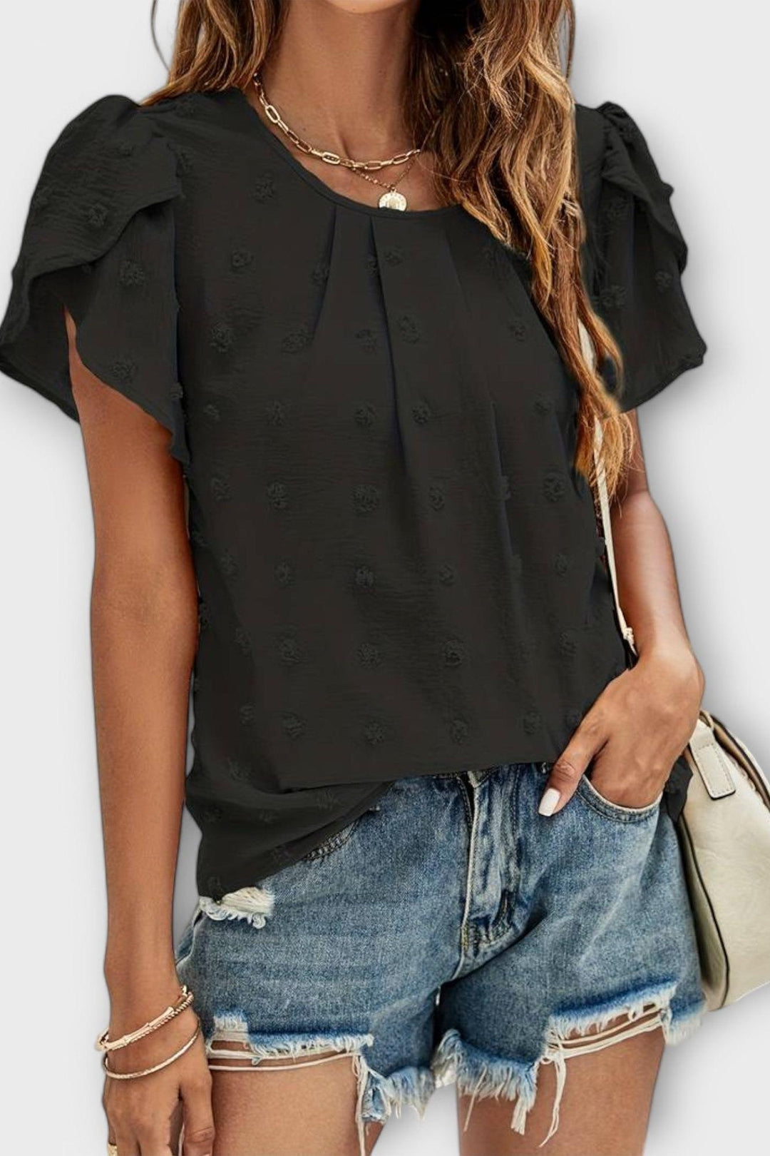 Tekstur af den lette Carlota damebluse, med fin struktur, komfortabel til varme sommerdage.