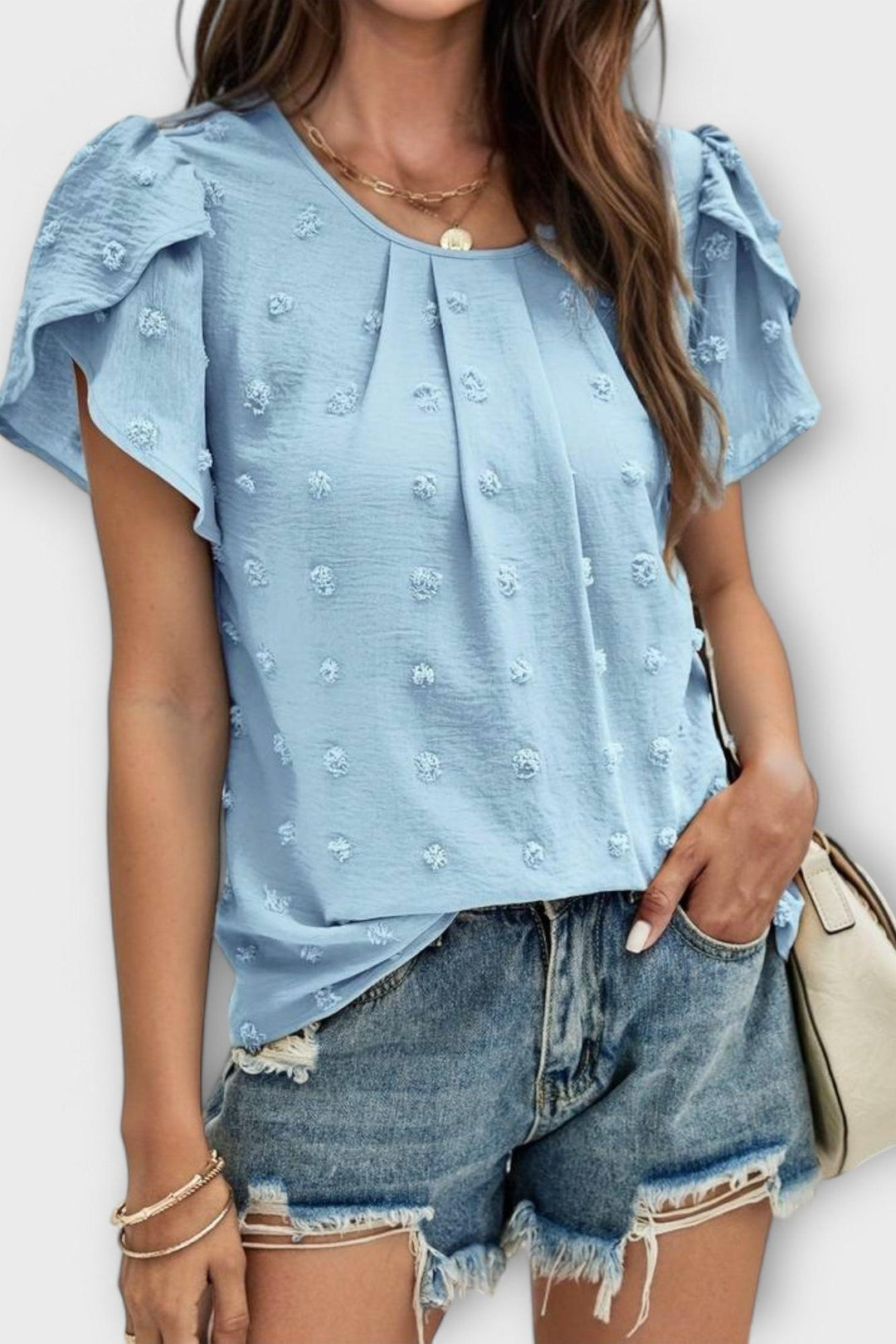 Model i feminin Carlota bluse med flæseærmer og struktur, afslappet og let stil til hverdag.
