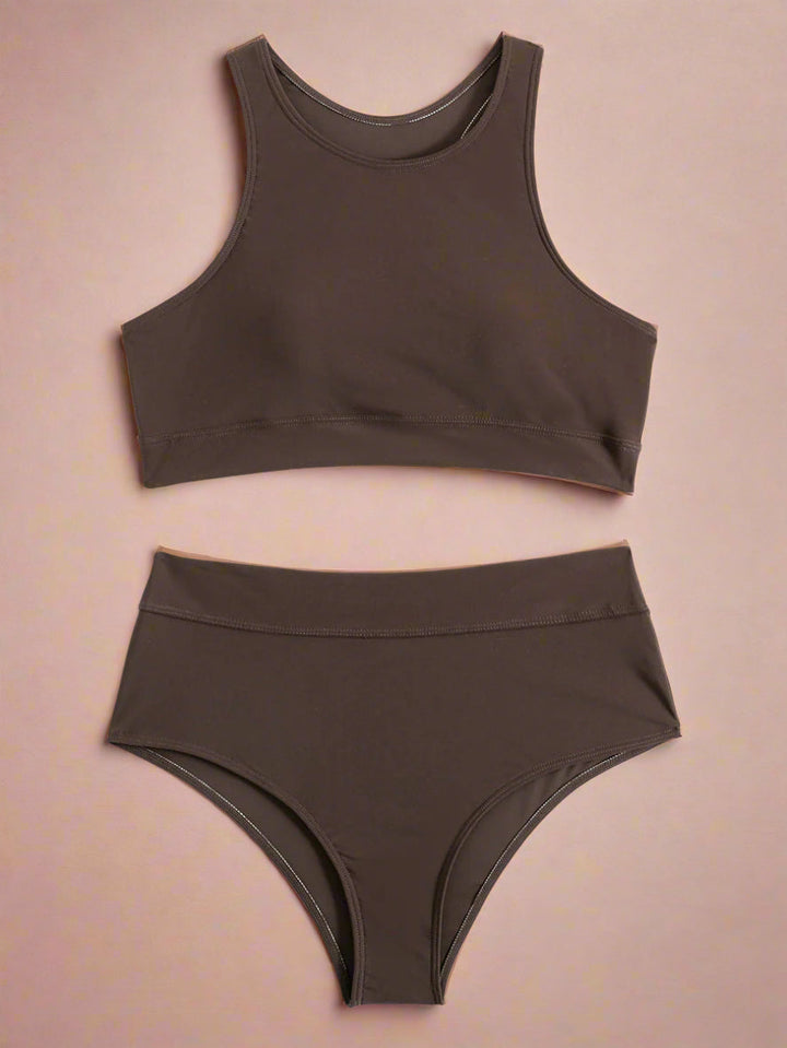 Kvinde i højtaljet badedragt slapper af ved poolen. Komfortabel sportsbikini, elegant dame badetøj til ferie.