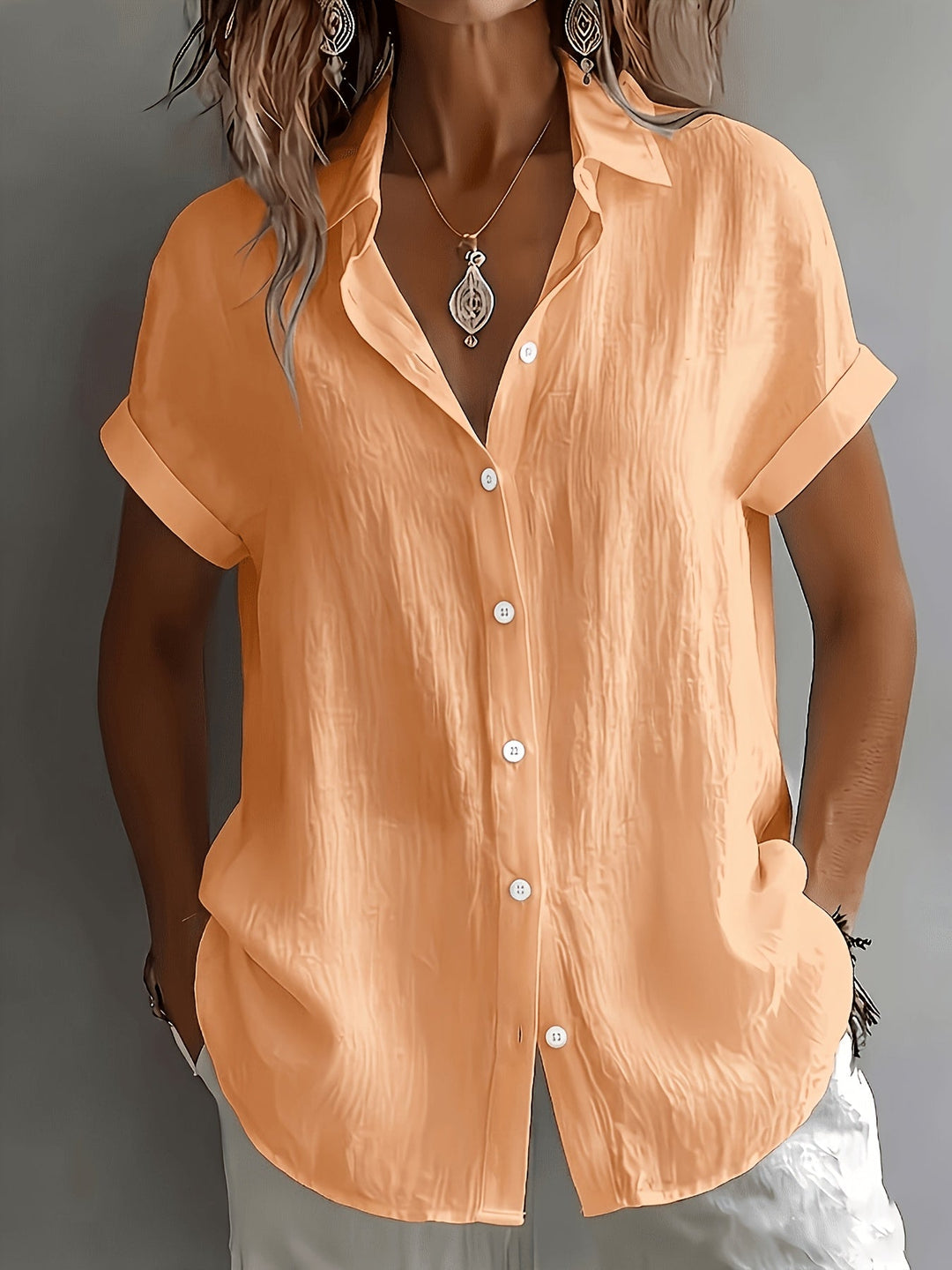 Stilfuld dame hørskjorte med korte ærmer og knaplukning, perfekt til et elegant og afslappet sommeroutfit.