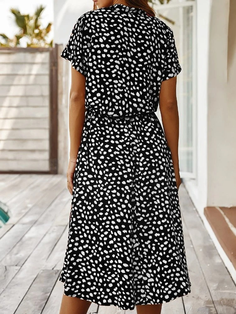 Model iført den elegante, luftige sommerkjole, der viser et smigrende snit og flot fald.
