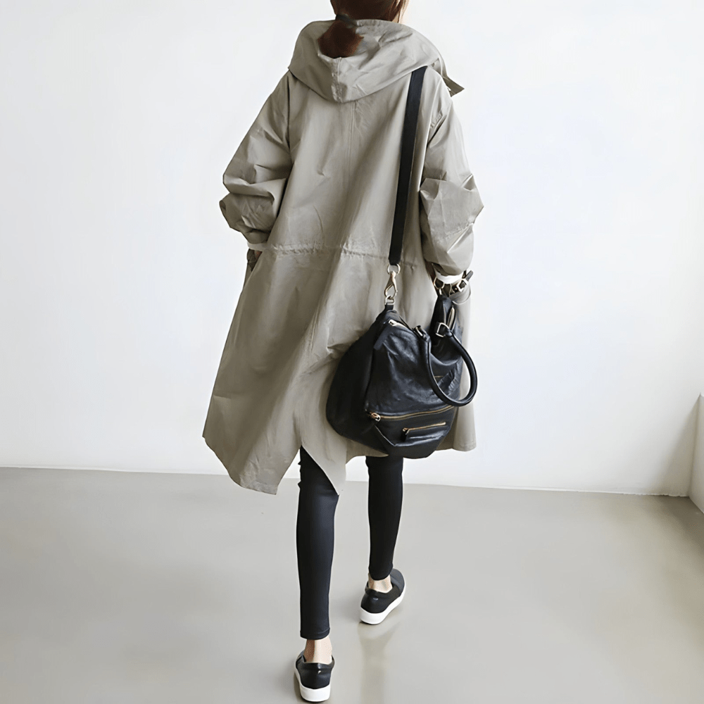Trendy dame oversized frakke med hætte og knaplukning. En moderne overgangsjakke til modebevidste.
