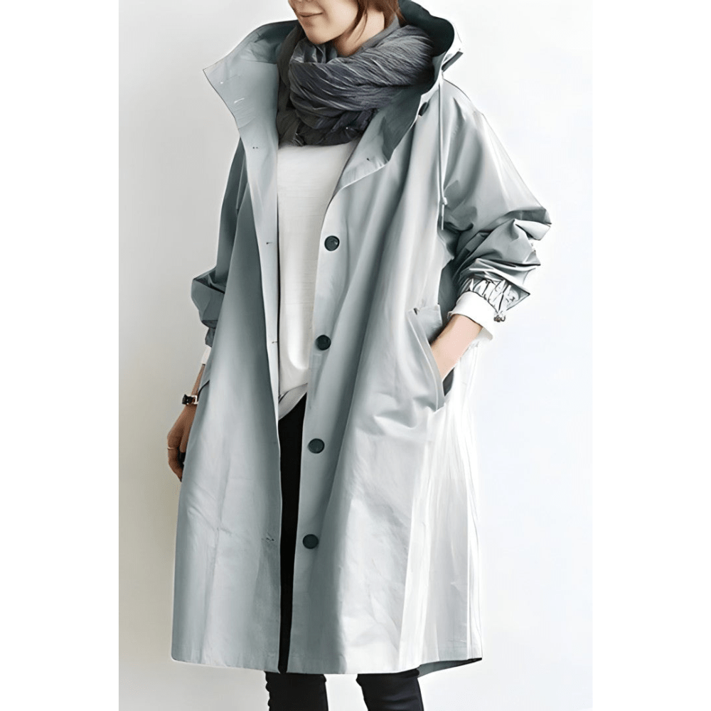 Lang dame hættet frakke i oversized design. Elegant og komfortabel vinterfrakke med knapdetaljer.