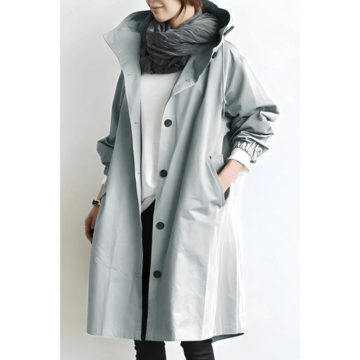 Lang dame hættet frakke i oversized design. Elegant og komfortabel vinterfrakke med knapdetaljer.