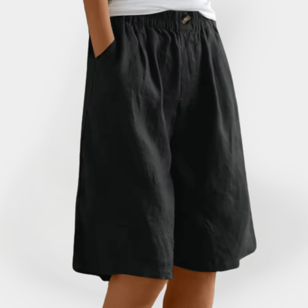Teksturdetalje af stoffet i dame sommer shorts, fremhævende lethed og åndbarhed for varme dage.
