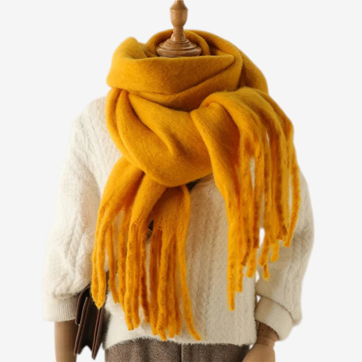 Elegant statement tørklæde med store, bløde frynser og unikt design.