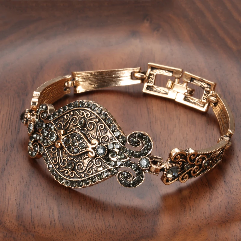 Dame vintage guldarmbånd med detaljerede ornamenter i antik stil. Et elegant bredt statement smykke.