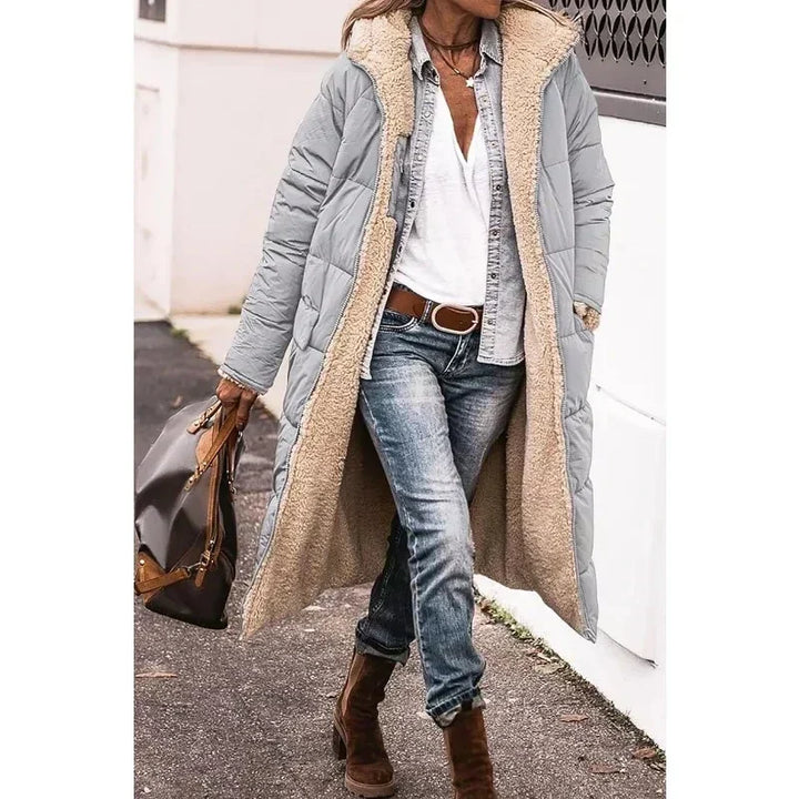 Stilfuld vinterfrakke til damer. Lang model med hætte, der giver varme og elegant vintermode.