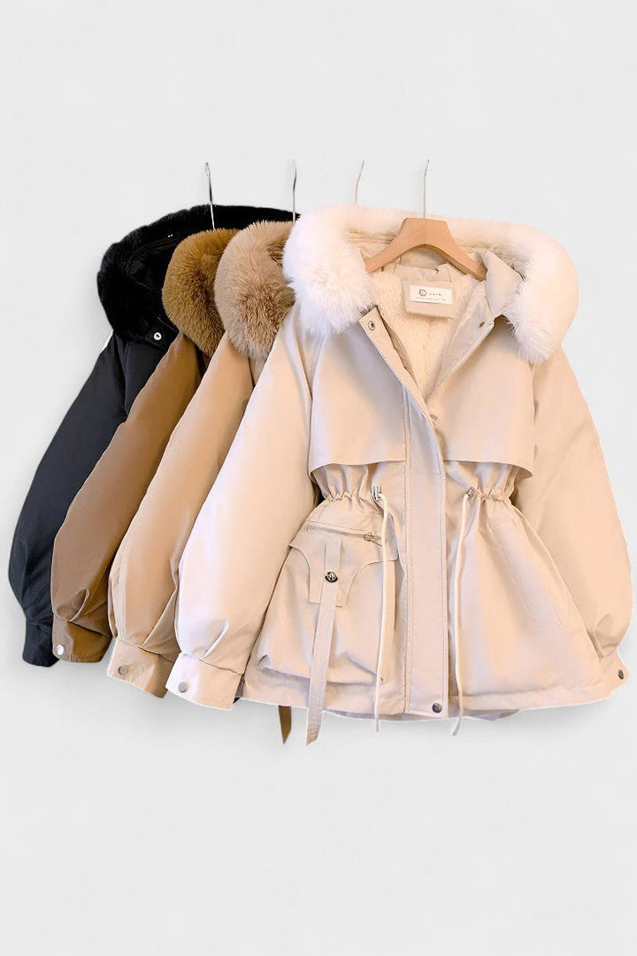 Damejakke med detaljeret faux fur hætte, kombinerer mode og varme til vinteren.
