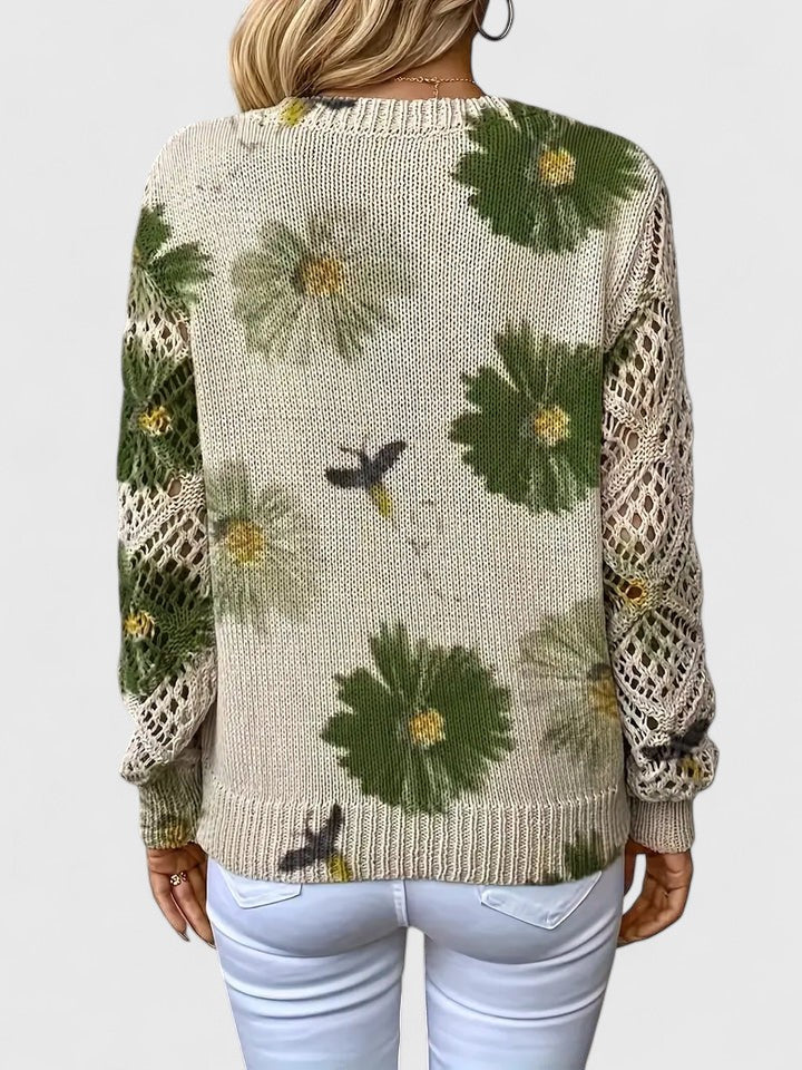 V-hals damebluse med forårsblomster og blondeærmer, stylet til et festligt arrangement.