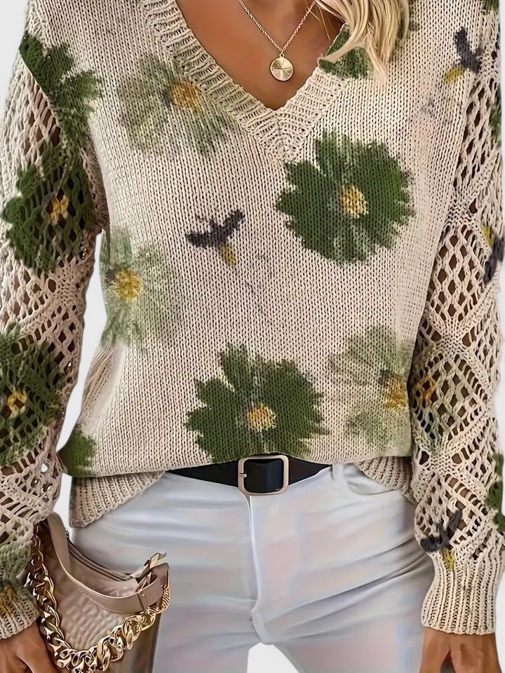 Feminin blomsterbluse med blondeærmer og V-hals, ophængt for at vise stof og design.