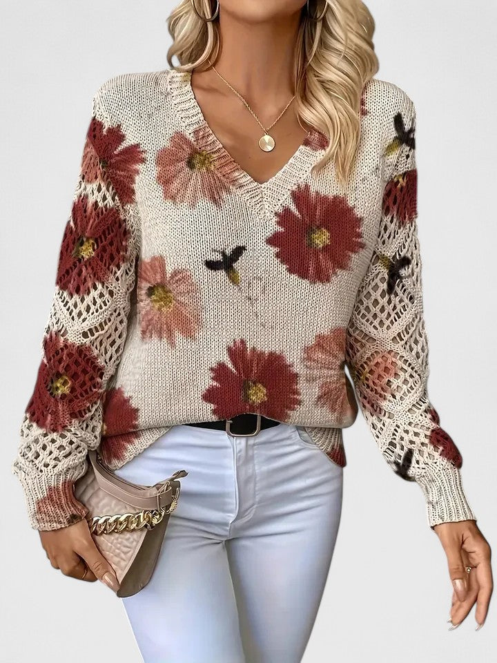 Detalje af V-halsudskæringen på den blomstrede damebluse med fine blondeærmer.