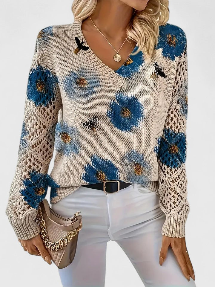 Detalje af blondeærmer på en blomstret V-hals damebluse. Elegant og feminin stil.