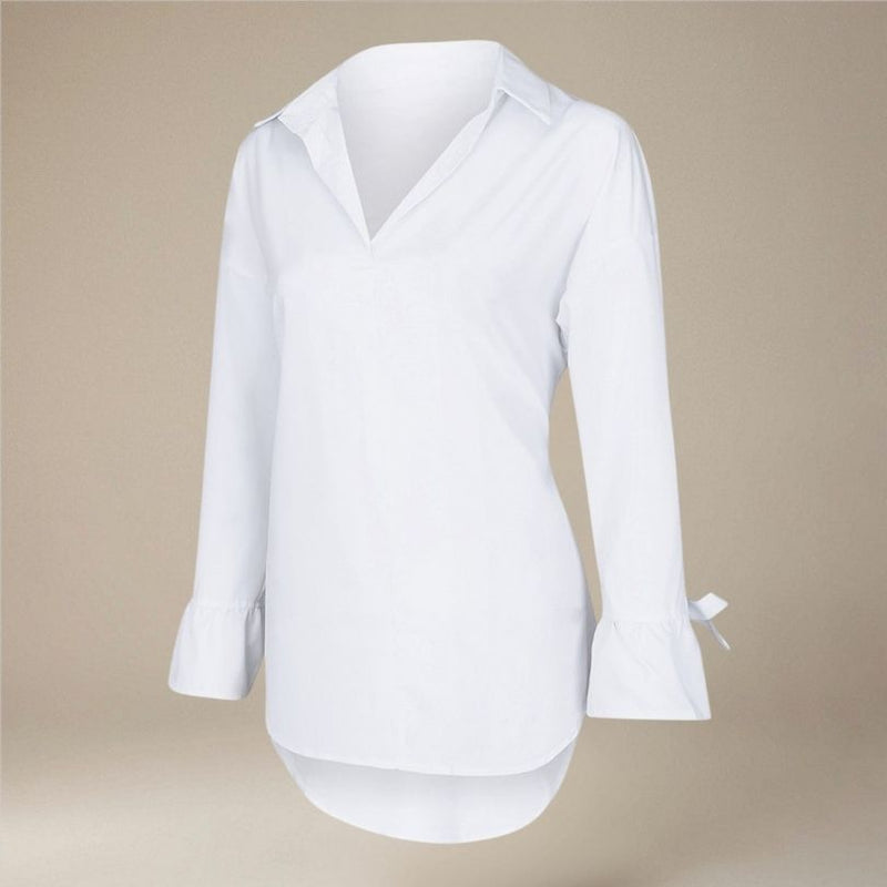 Nærbillede af den elegante sløjfe på den hvide langærmede damebluse, der tilføjer et chic touch til looket.