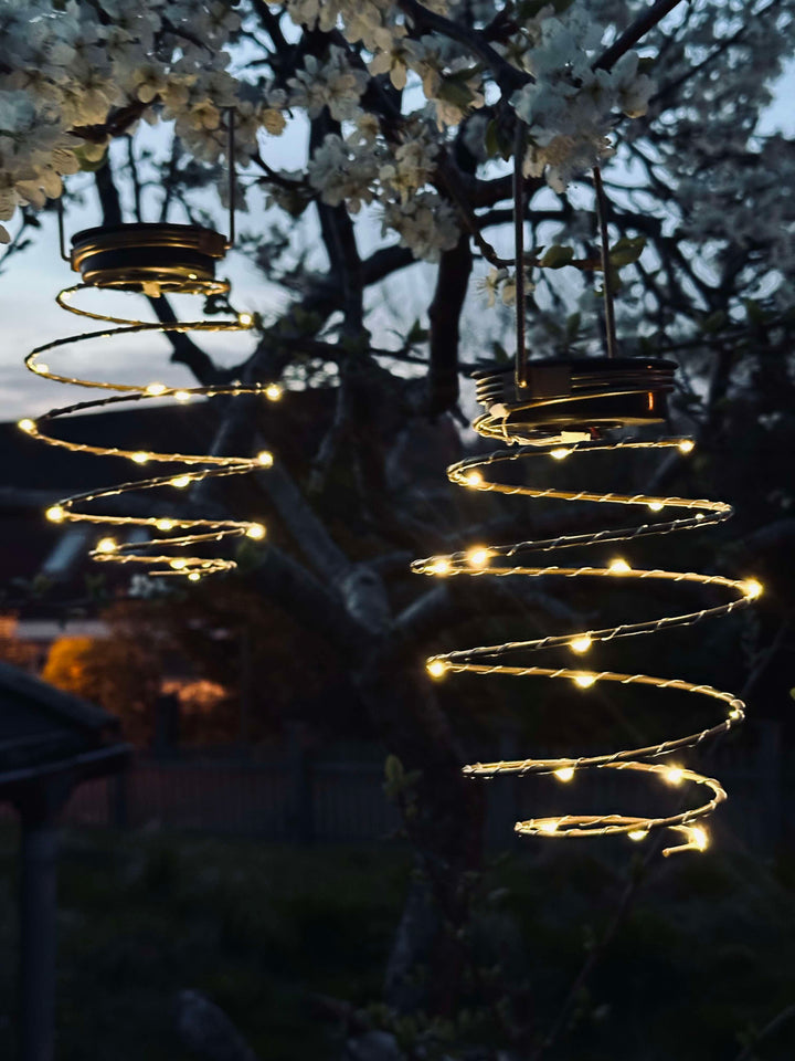 Dekorativ solcelle spiral LED lanterne i gylden metal. Miljøvenlig havebelysning til udendørs dekoration.
