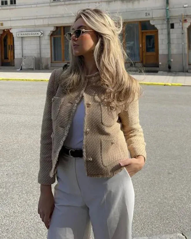 Kvinde i stilfuld beige efterårsfrakke, der udstråler elegance. Komfortabel og tidløs klassiker til overtøj.