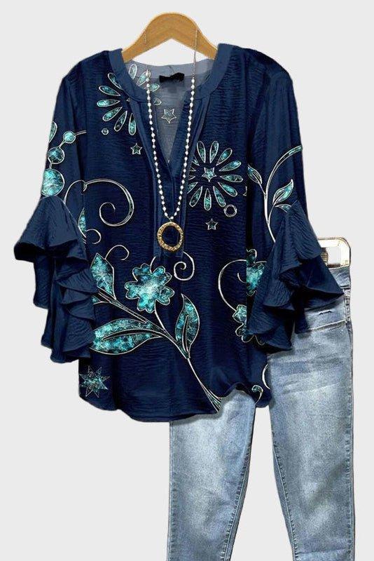 Elegant blå damebluse med levende blomstermotiv og feminine flæseærmer for stilfuld komfort.
