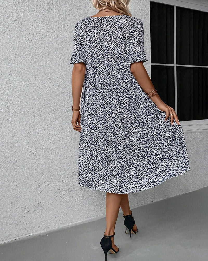Feminin blomstret midikjole med smukt mønster, ideel til forårsmode og sommerdage.