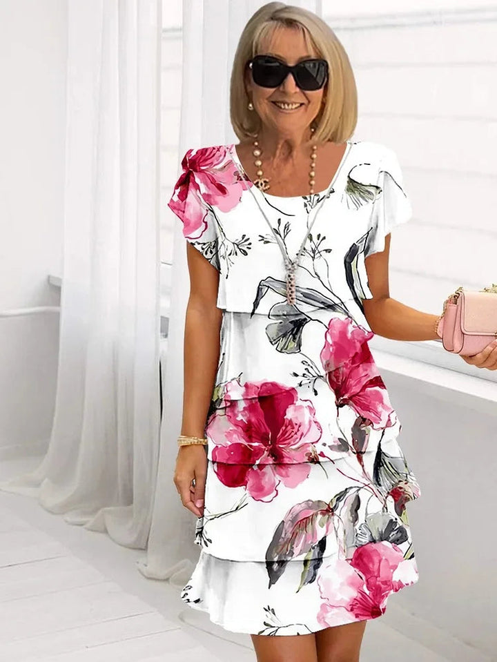 Elegant blomstret plisseret sommerkjole til kvinder med feminine flæser, perfekt til fest og hverdag.