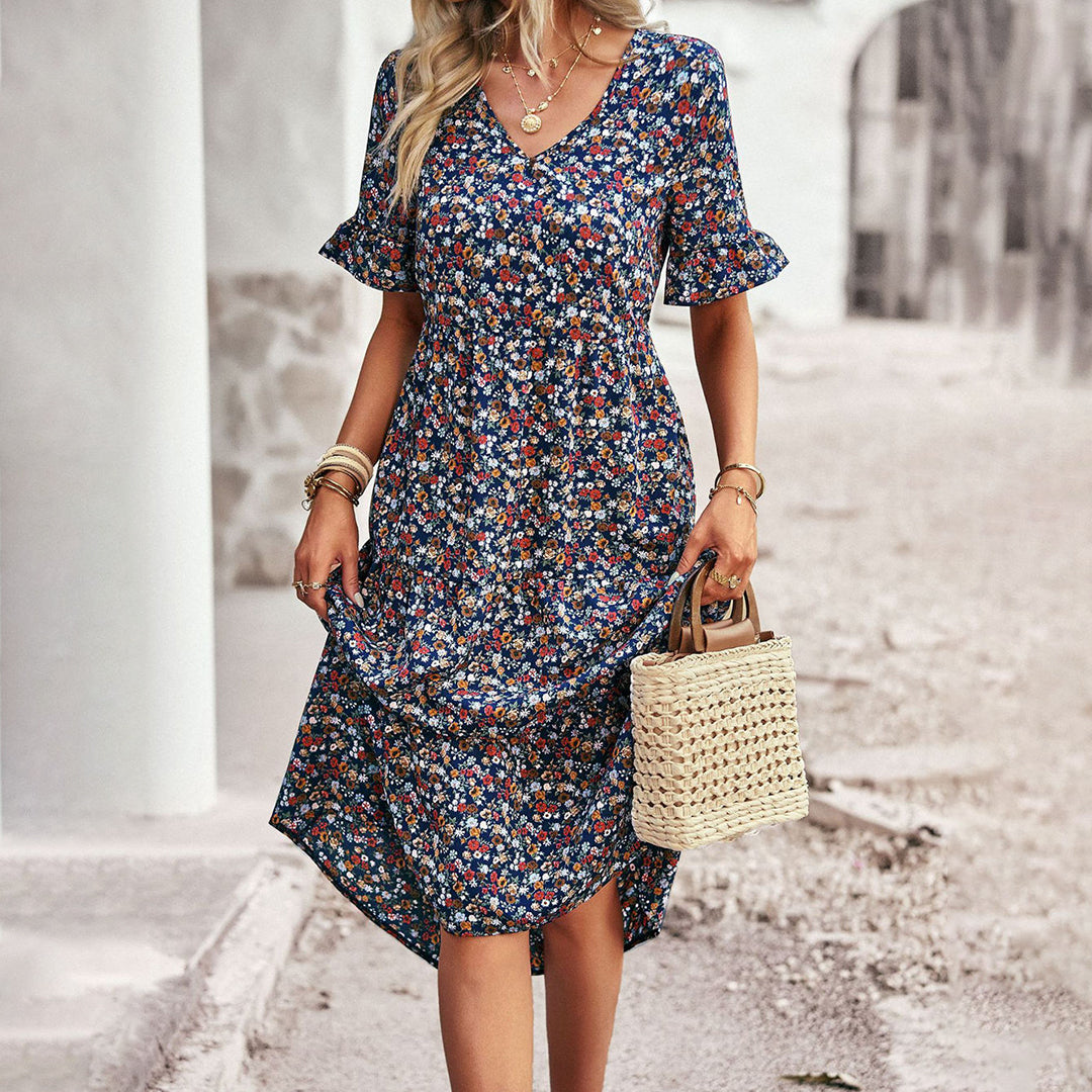 "Elegant boho blomstret sommerkjole i blå med V-udskæring og flagrende ærmer, let pasform til feminint look."