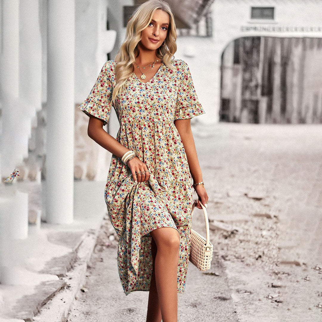 "Elegant boho blomstret sommerkjole i blå med V-udskæring og flagrende ærmer, let pasform til feminint look."