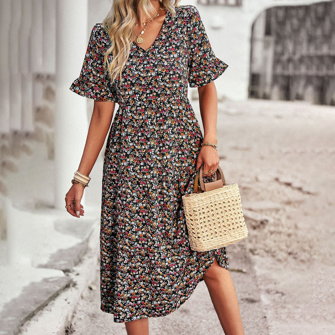 "Elegant boho blomstret sommerkjole i blå med V-udskæring og flagrende ærmer, let pasform til feminint look."