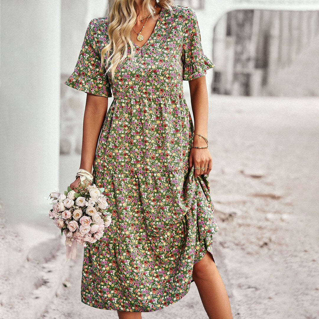 "Elegant boho blomstret sommerkjole i blå med V-udskæring og flagrende ærmer, let pasform til feminint look."