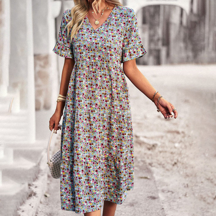 "Elegant boho blomstret sommerkjole i blå med V-udskæring og flagrende ærmer, let pasform til feminint look."