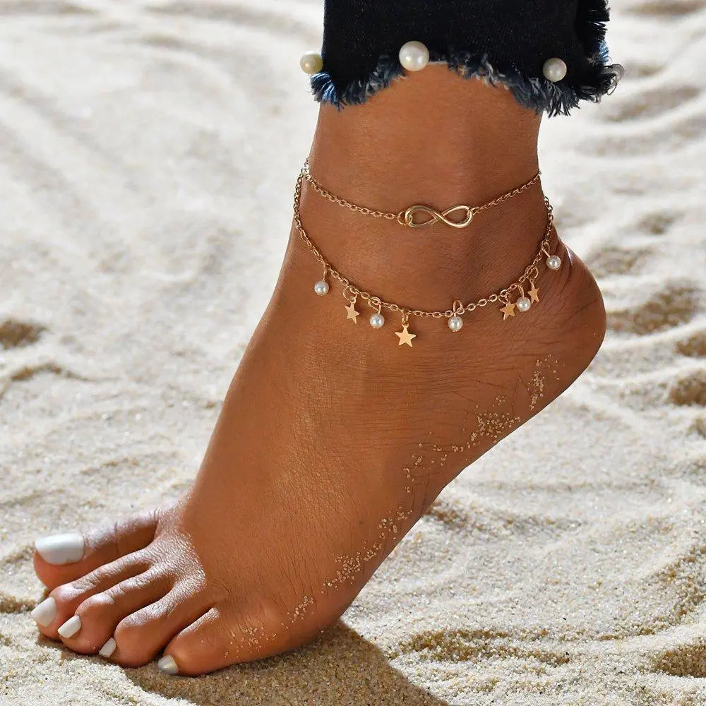 Elegant dame ankelkæde med små, skinnende vedhæng, perfekt til sommer og strand. Tilføj et stilrent touch.