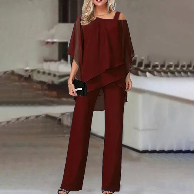 "Elegant dame buksedragt med asymmetrisk design, off-shoulder og brede bukseben, perfekt til festlige lejligheder."