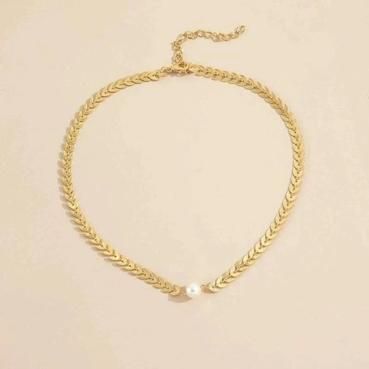 Moderne flettet guld choker halskæde med en smuk klassisk perle. Justerbar og stilfuld perlehalskæde.