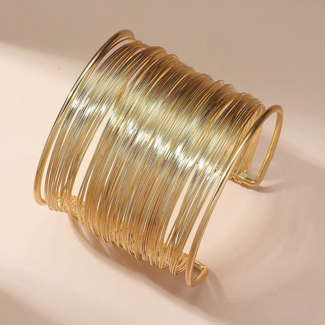 Elegant dame guld bangles sæt i lag-på-lag design. Perfekt som minimalistisk smykke til fest og hverdag.