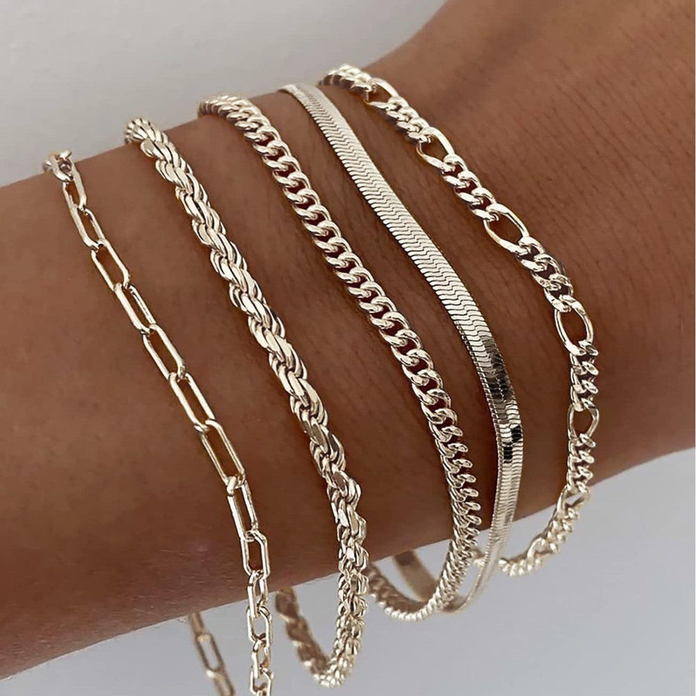 Moderne dame armbåndssæt med individuelle guld- og sølvkædearmbånd, der skaber et lag-på-lag look.