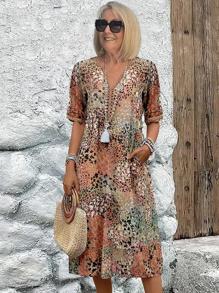 Elegant dame midi-kjole med farverigt, levende print og flatterende v-hals, perfekt til sommer eller fest.