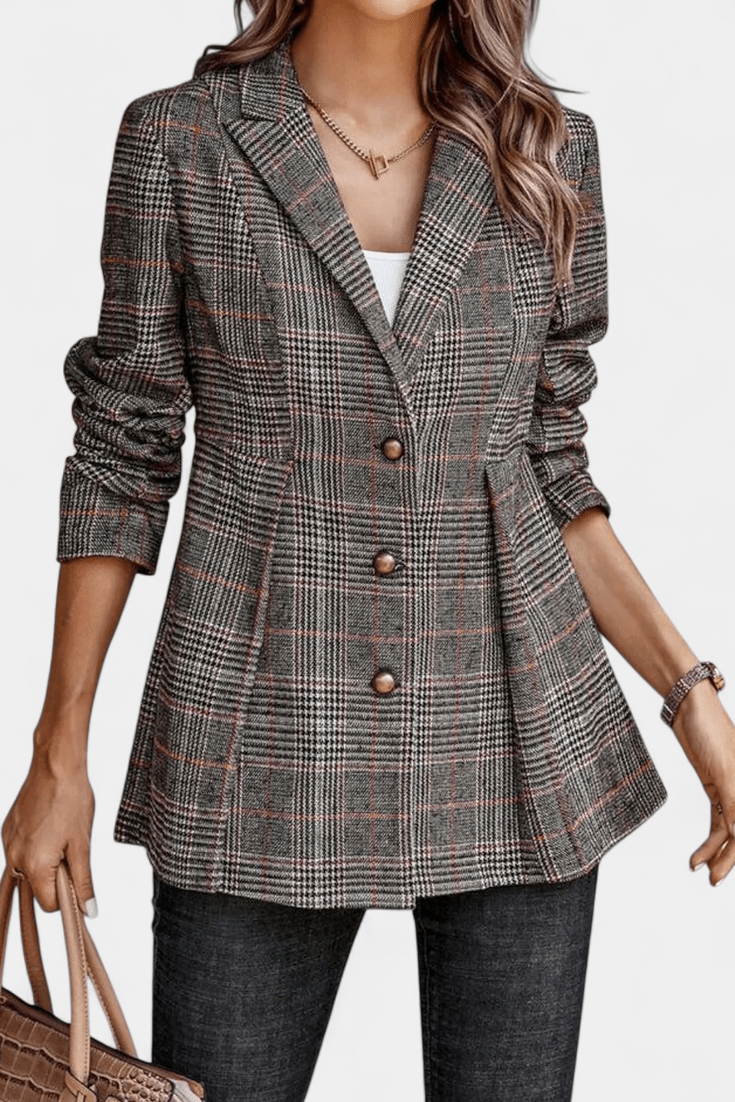 Nærbillede af rutet peplum blazer, viser det elegante mønster og kvaliteten af dameblazeren.