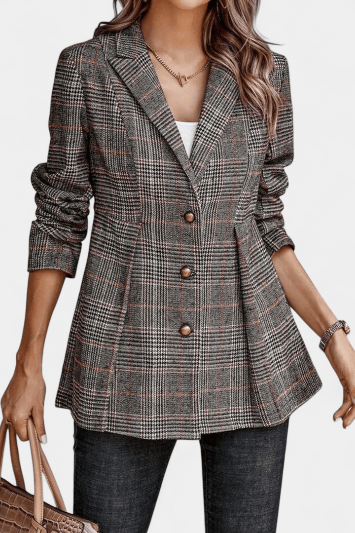 Nærbillede af rutet peplum blazer, viser det elegante mønster og kvaliteten af dameblazeren.