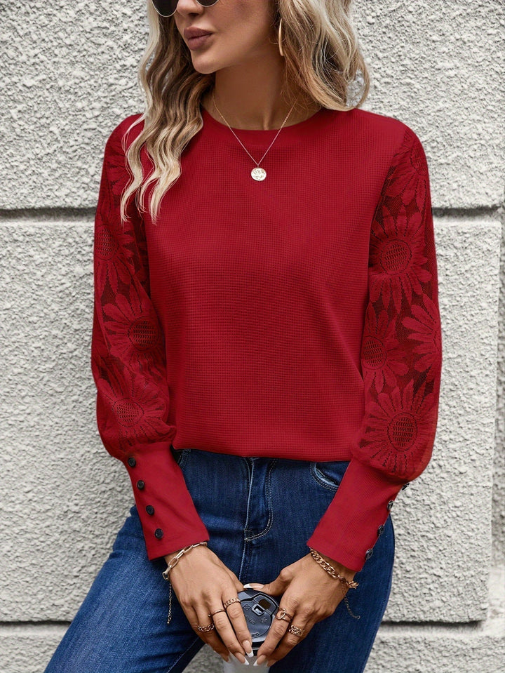 Alsidig damebluse med delikate blondeærmer. En elegant top til enhver lejlighed.