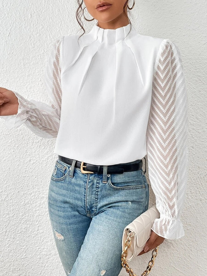 Elegant damebluse med høj hals og smukke transparente ærmer. Perfekt til fest eller en sofistikeret hverdag.